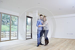 Happy Young Couple Looking At Details Of New Home