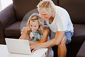 Happy young couple looking at laptop