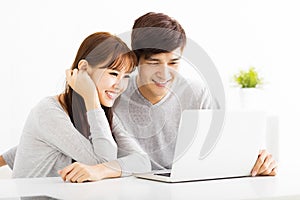 Happy young Couple Looking at Laptop