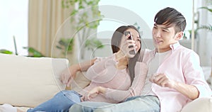 Happy young couple  looking at mobile phone in living room at home