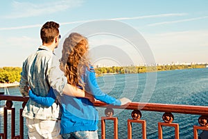 Happy young couple in love embracing each other on the bridge