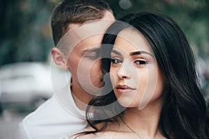 Happy young couple in love enjoys spring day, loving man holding on hands his woman carefree walking at park