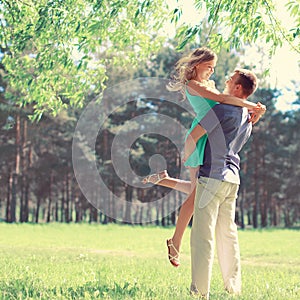 Happy young couple in love enjoys spring day, loving man holding on hands his woman carefree walking in park