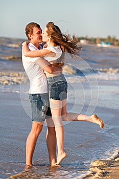 Happy young couple in love have fun on beautiful beach at beautiful summer day