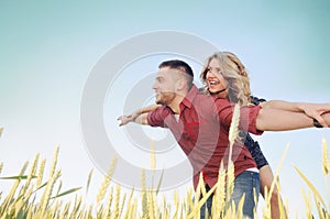 Happy young couple in love have romance and fun at wheat field i