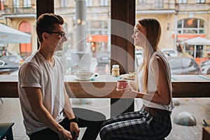 Happy young couple in love having a nice date in a bar or restaurant. They telling some stories about themself