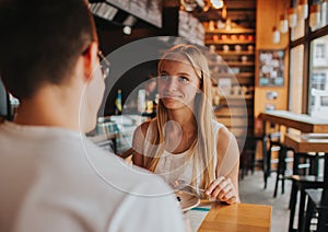 Happy young couple in love having a nice date in a bar or restaurant. They telling some stories about themself