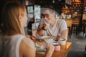 Happy young couple in love having a nice date in a bar or restaurant. They telling some stories about themself