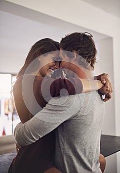 Happy young couple, love and hug in apartment for care, quality time and bonding together for commitment to relationship