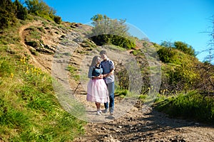 Happy young couple in love hugging enjoys spring day, loving man holding on hands his woman carefree together outdoors