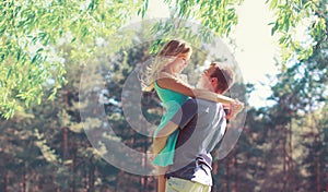 Happy young couple in love hugging enjoys spring day, loving man holding on hands his woman carefree together outdoors walking