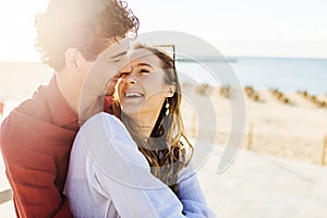 Happy young couple in love looking at each other at beach
