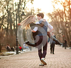 Happy young couple in love newlyweds joyfully having fun in city park