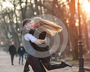 Happy young couple in love newlyweds joyfully having fun in city park