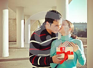 Happy young couple in love with present outdoors