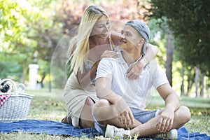 Happy young couple in love relaxing and having picnic in park
