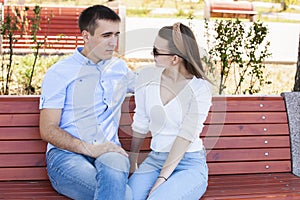 Happy young couple in love sitting on a park bench