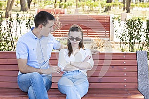 Happy young couple in love sitting on a park bench