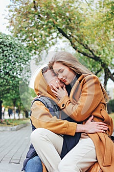 Happy young couple in love teenagers friends dressed in casual style kissing on the autumn city street