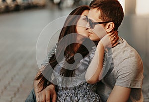 Happy young couple in love teenagers friends dressed in casual style kissing at street