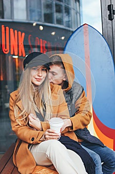Happy young couple in love teenagers friends dressed in casual style walking together on city street in cold season
