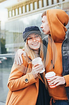 Happy young couple in love teenagers friends dressed in casual style walking together on city street in cold season