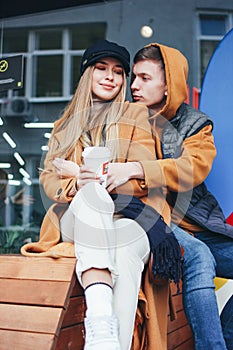 Happy young couple in love teenagers friends dressed in casual style walking together on city street in cold season