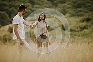 Happy young couple in love walking through grass field