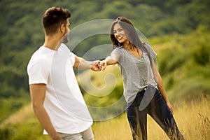 Happy young couple in love walking through grass field