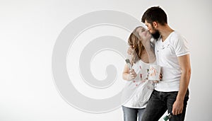 Happy young couple in love in white t-shirts makes renovations, getting ready to move to a new home, selective focus