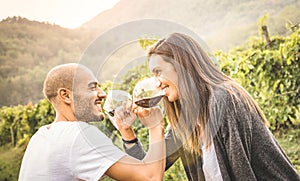 Happy young couple of lover drinking red wine at vineyard