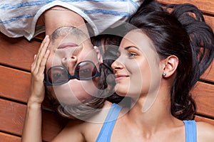 Happy young couple lying on a wooden floor