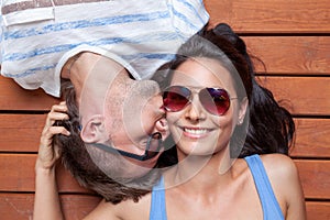 Happy young couple lying on a wooden floor