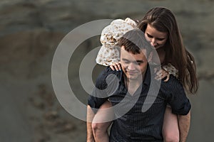 Happy young couple. Man piggybacking his girlfriend in summer