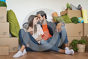 Happy young couple moving in new home first time - Man and woman having fun unpacking carton box in new property house