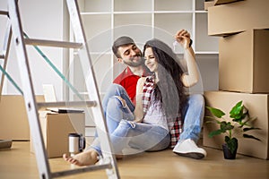 Happy young couple moving in new home unpacking boxes