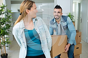 Happy young couple moving in new home unpacking boxes