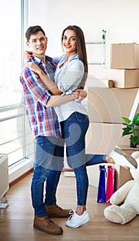 Happy young couple moving together in new apartment