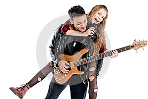 Happy young couple of musicians with microphone and electric guitar performing music together