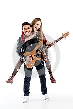 Happy young couple of musicians with microphone and electric guitar performing music together