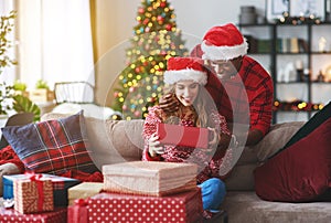 Happy young couple opening presents on Christmas morning