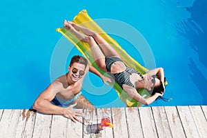 Happy young couple in outdoor  pool, above view