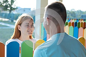 Happy young couple outdoors. Girl and boy looking at each other