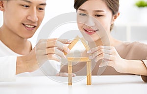 Happy young couple playing with toy blocks