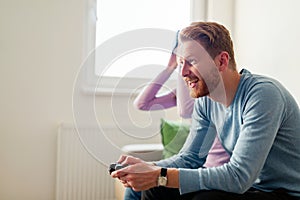 Happy young couple playing video games with virtual reality headsets