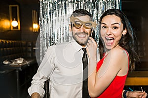 Happy young couple posing together at nightclub