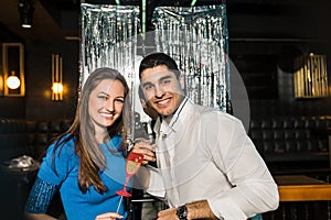 Happy young couple posing together at nightclub