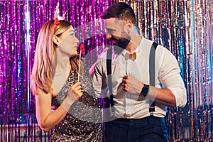 Happy young couple posing together at nightclub