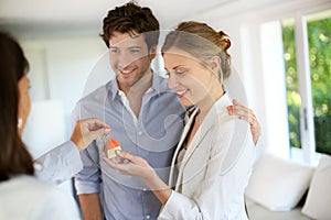 Happy young couple receiving keys of their new home