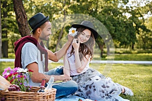 Happy young couple relaxing and having picnic in park
